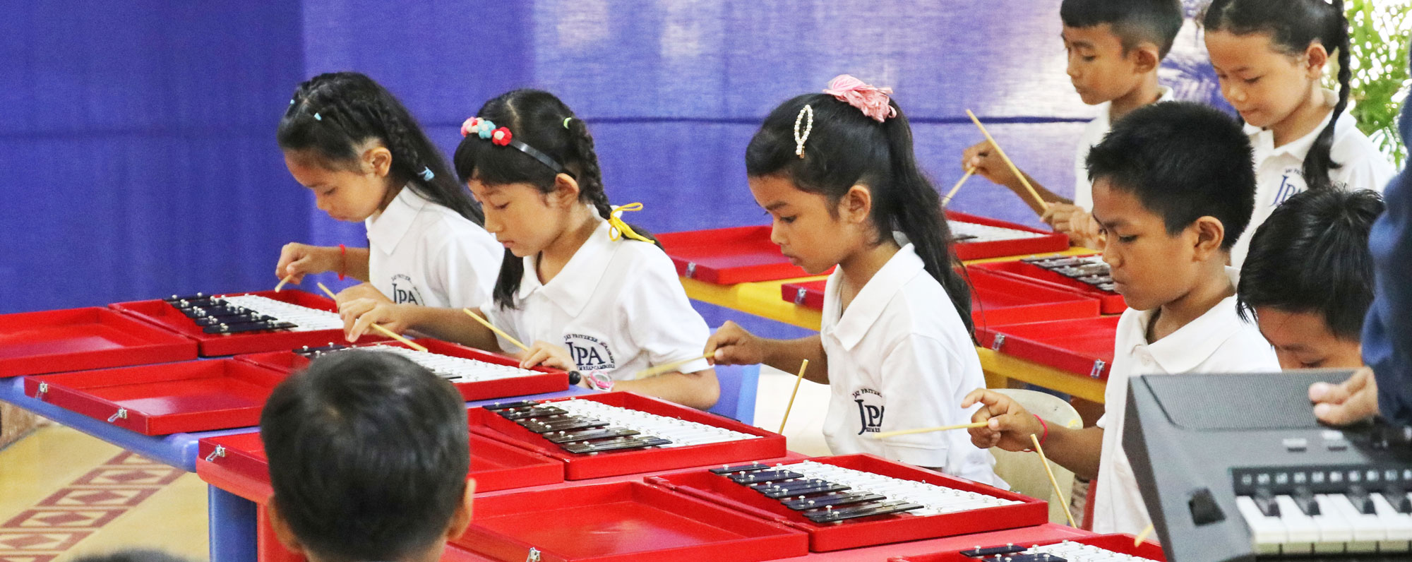 JPA student musicians performing at assembly. Jay Pritzker Academy, Siem Reap, Cambodia. Jay-Pritzker-Academy-Siem-Reap-Cambodia.